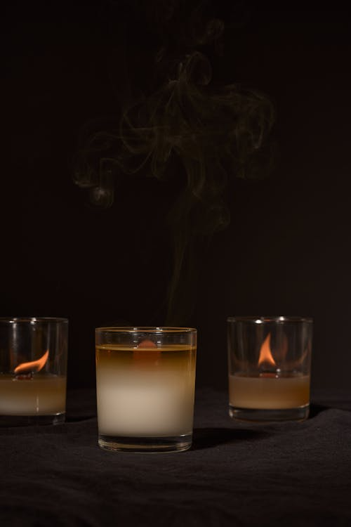 Burning and extinguished candles on a dark surface.